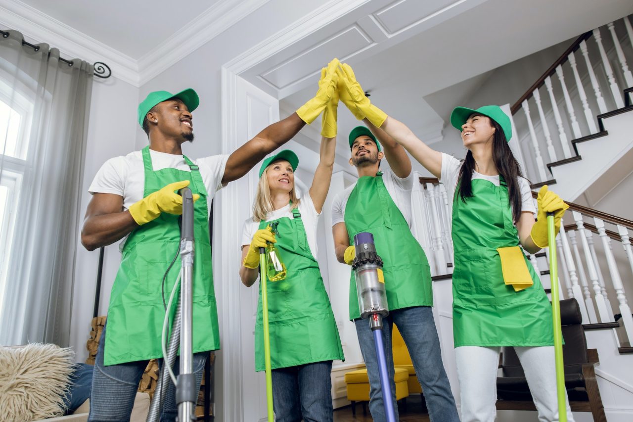 happy-multiracial-cleaners-giving-high-five-after-cleaning